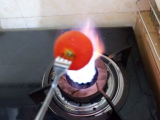 新手必看  番茄土豆汤,番茄用叉子戳着，放在火上直接烧，转动叉子，让番茄受热均匀，番茄皮完整的番茄在听到啵的一声的时候就好了。这是我常用的番茄去皮方式。当然，也可以在番茄顶端划十字，泡开水来去皮。没有明火的就需要这样。