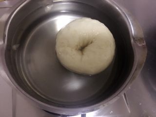 杏仁片贝果,
倒入锅里烧开关小火，
依次放入发酵好的面团
每面煮20-30秒
捞出沥干水分
