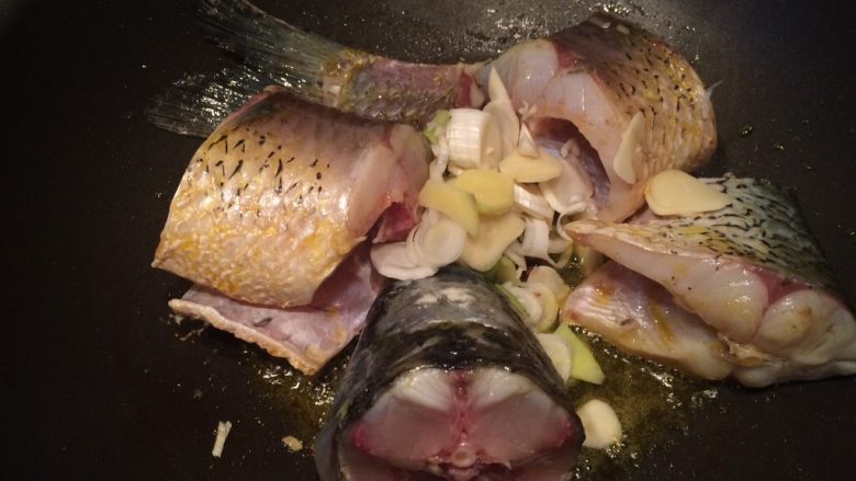 家常炖鱼,倒入葱姜蒜爆香，注意不要火太大，鱼皮容易糊锅