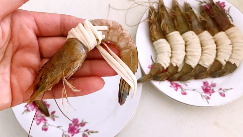 颜值爆表的  香酥玉带虾,取一只海青虾，用泡好的3根面条缠住中间虾肉部分