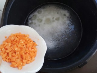 龙利鱼蔬菜粥,粥烧开后放入胡萝卜丁