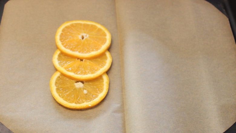 橙汁纸包鱼,将柳橙片迭放在烤盘纸的一侧。