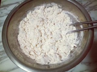 荷叶夹-馒头,把融化的酵母水加入面粉器具中，并用筷子搅拌，挑成絮状。(面粉吸水量不同，请根据实际情况增减水量)