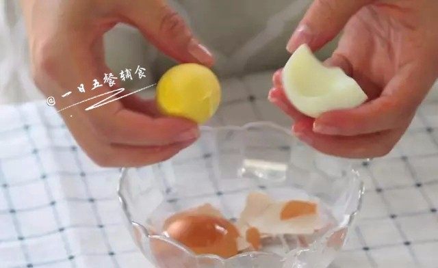 菠菜蛋黄十倍粥,粥煮了约30分钟，将鸡蛋拿出来剥壳，去白。