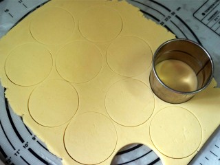香肠糖霜饼干,用圆形饼干模压制饼干胚，并将饼干胚转移到烤盘上。