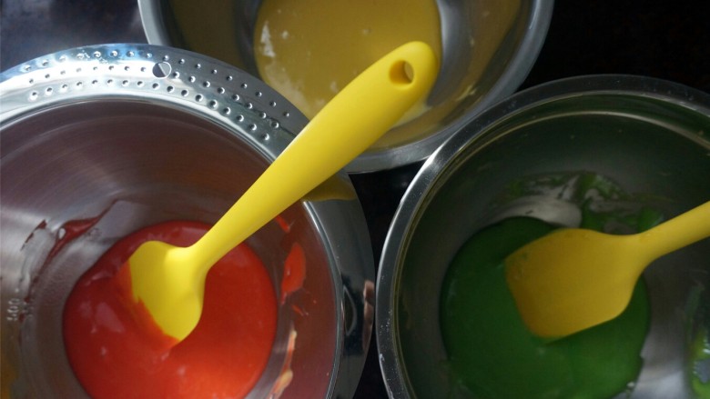 棋格蛋糕,将蛋黄糊平均分成三份，其中两份分别滴入红色素和绿色素，拌均匀。