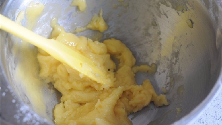 #不一样的泡芙#卡士达酱泡芙,用硅胶刀搅拌，将蛋液混入面糊里面，这个时候，面糊还很轻，蛋液和面糊立刻就能混合在一起，比较轻松。