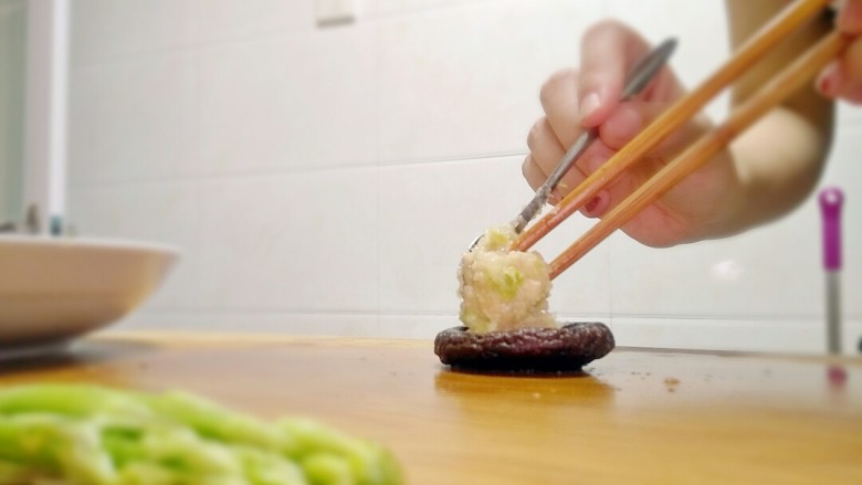 芦笋香菇鸡肉丸
（香菇鸡肉盏）,用勺子和筷子把鸡肉丸整理好形状。