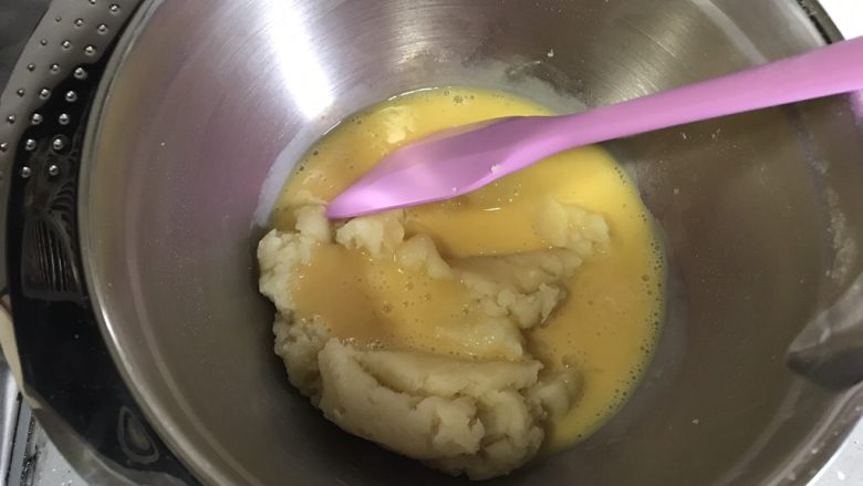 ＃不一样的泡芙＃香草泡芙,加入一半全蛋液，切拌烫熟的面粉吸收鸡蛋液。