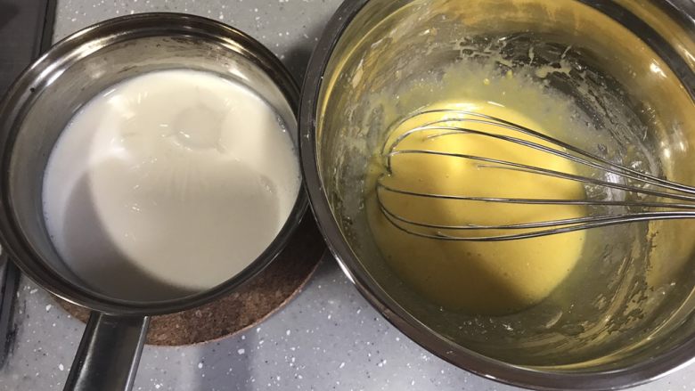 ＃不一样的泡芙＃香草泡芙,牛奶加热沸腾后慢慢倒入蛋黄糊，边倒边搅拌。