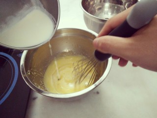 #不一样的泡芙#酷黑的黑森林泡芙,将牛奶缓慢的加入蛋黄液中混合均匀即可