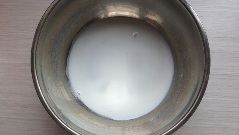 自制浓稠酸奶,盆里倒入少量牛奶。