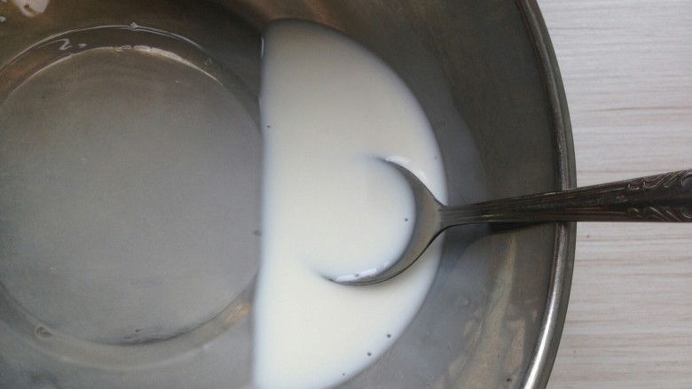 自制浓稠酸奶,用汤匙搅拌均匀，使发酵菌全部溶解于牛奶里。