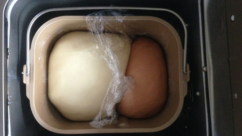 双色水果面包杯,将原色面团和可可面团放进面包桶内，发酵45分钟。