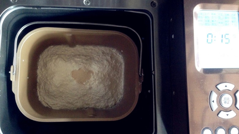 双色水果面包杯,将面粉放进面包桶，面粉上端放入酵母，启动面包机和面功能，和面15分钟。
