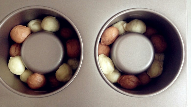 双色水果面包杯,第二层的小面团放在底下两个面团之间的位置上方，也是错开颜色。