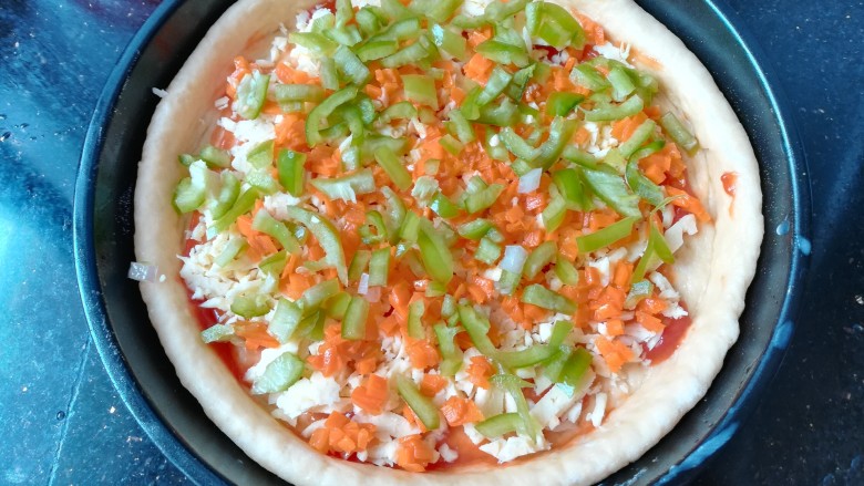 自制披萨,依次放入胡萝卜和青椒。