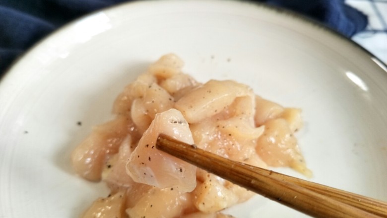 口蘑芦笋炒鸡胸,撒上一勺盐和一些研磨黑胡椒，抓匀腌制几分钟。