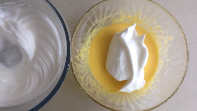 柠檬戚风纸杯蛋糕,取三分之一打发好的蛋白霜，加入到蛋黄糊里，从底部向上翻拌均匀