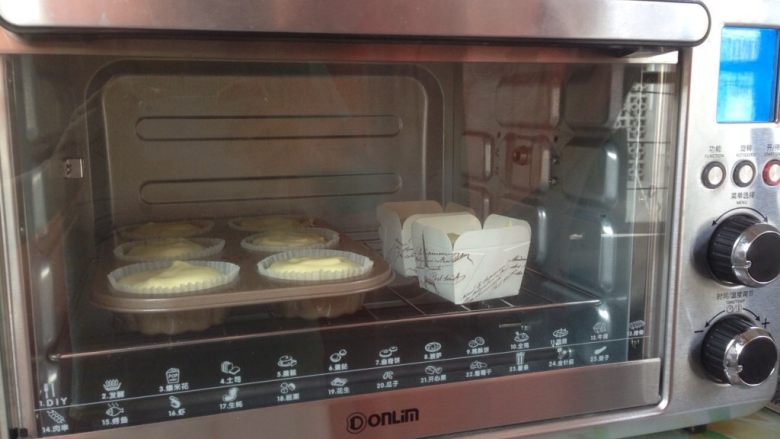 柠檬戚风纸杯蛋糕,放入到已经提前预热好的上火160度，下火140度的烤箱下层，烘烤35分钟左右。