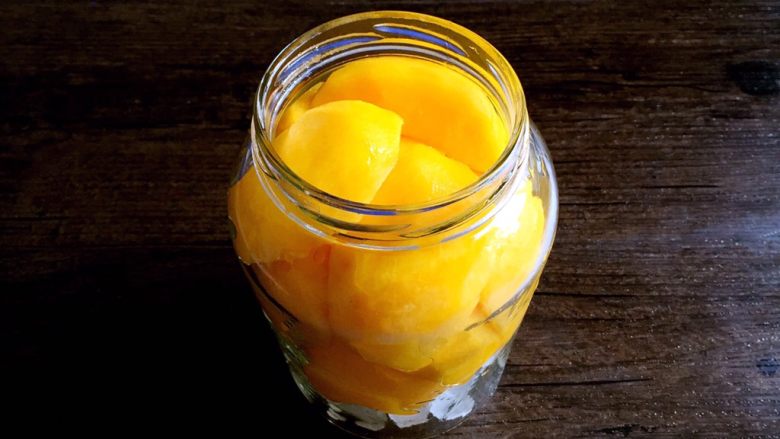 自制黄桃罐头—真正的安全无添加,装入黄桃块。自己做就是比较实惠，塞的满满的，哈哈～