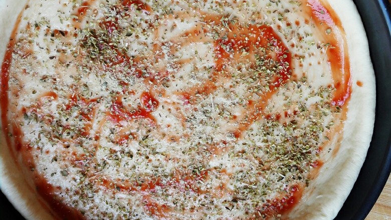 海鲜披萨,撒上少许盐，再撒上一层胡椒粉和牛至叶（披萨草）
