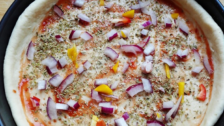 海鲜披萨,撒上少许圆葱和青红椒，注意不要放多了，不然会出水。