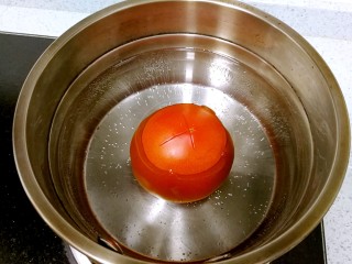 番茄焖红衫鱼,番茄顶部切个十字，放热水里小火煮一会儿。
