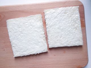 快手早餐：西多士,切好的吐司面包平平放在案板上 两块吐司片抹一层薄薄的色拉酱