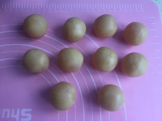 莲蓉蛋黄月饼（50克）,然后莲蓉捏成小圆皮包住蛋黄。搓圆备用。