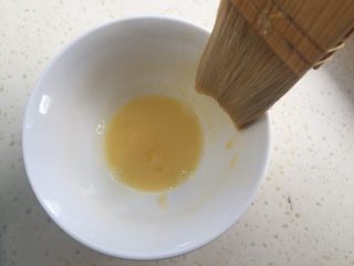 莲蓉蛋黄月饼（50克）,准备蛋黄液。一个蛋黄加入10克水调匀。