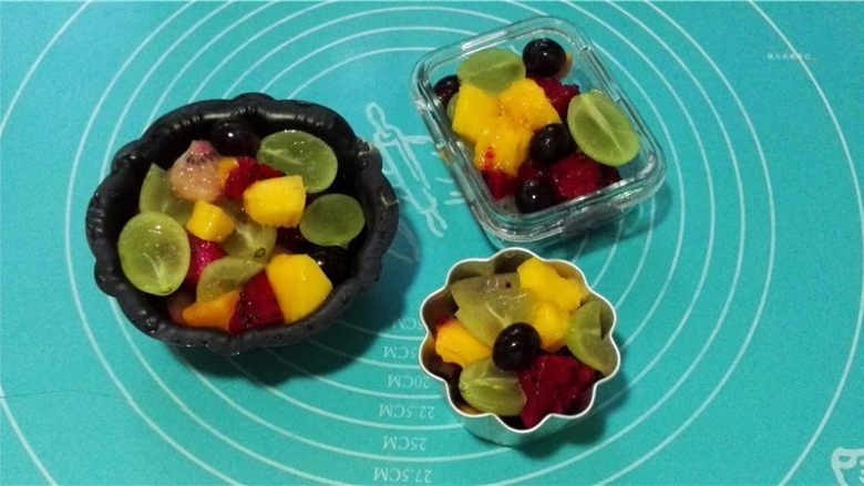 鲜果沙巴翁,将处理好的水果均匀地放入容器中备用。这里要注意表面水果的色彩搭配。