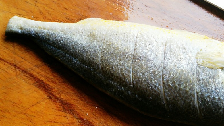 清蒸黄鱼,在鱼的身上两面斜切几刀。