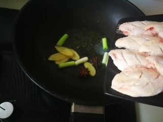 红烧鸡翅,放入鸡翅，翻炒。待两面金黄后加入清水。