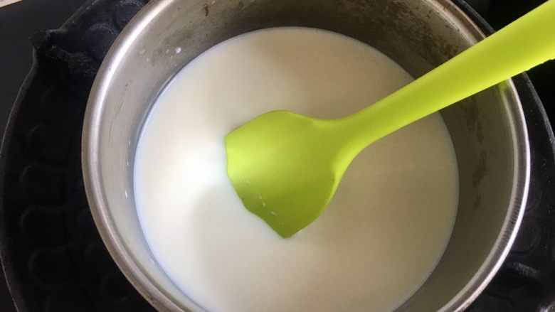 自制炼乳（奶粉版）,倒入奶锅，小火加热，要用刮刀不停的超底搅拌，防止糊底。