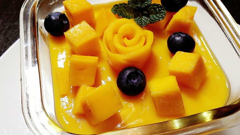 芒果布丁,等到布丁凝固后，拿出来放入预留的芒果丁或者喜欢的水果装饰。