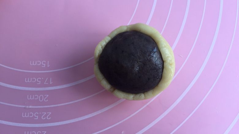 奥利奥蛋黄月饼（50克）,然后手沾点油，把饼皮捏成小圆包裹住馅料圆球，往上推。