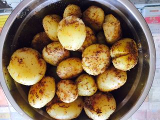 孜然椒盐小土豆,用菜刀将小土豆全部拍扁，撒上盐，椒盐，孜然粉，颠动容器让土豆们都沾上调料腌制一小时