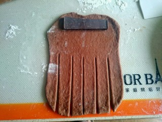 巧克力毛毛虫面包,松弛以后，在揉面垫上撒点高粉，把面团檊成长方形，下半截，切成这种胡子形，上半截放巧克力