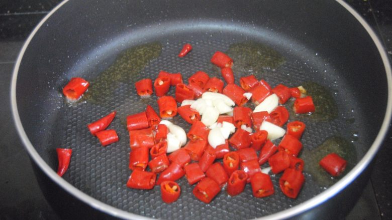 辣子鸡, 热锅，倒入适量的金龙鱼外婆乡小榨菜籽油，爆香蒜末后放入湿辣椒炒至表皮起泡