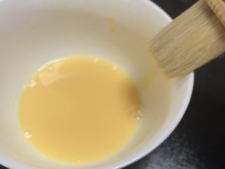 广式五仁月饼,一个蛋黄加10克水调均匀后过筛两边，蛋液刷之前刷子要在碗边刮几下，