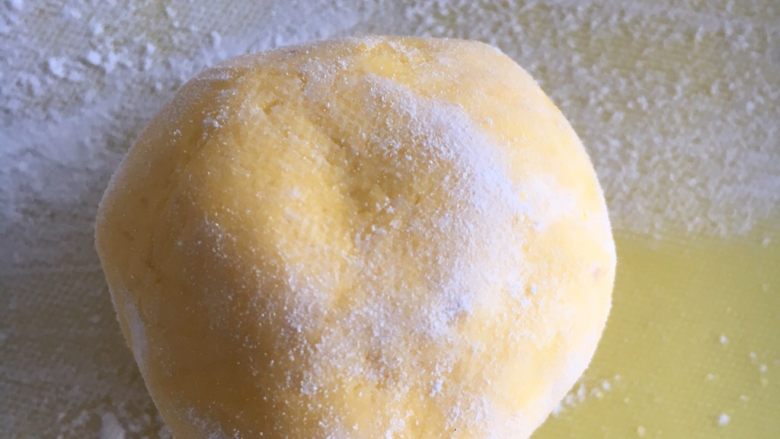 奶香南瓜月饼,把做好的胚子在干粉里滚上一圈