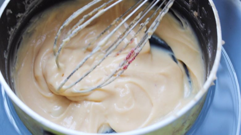#不一样的泡芙#樱花卡仕达酱萝莉泡芙,如图所示，变成粘稠状后迅速连同小奶锅座入冰水里。继续搅拌。