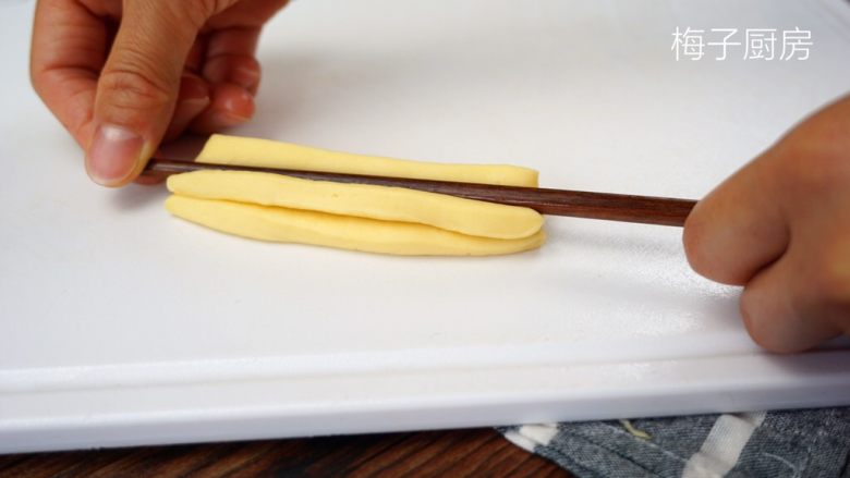 自制油条,用筷子按压中间。