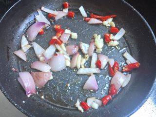 升级版鸡翅鸡腿吃法。,4⃣️在平底锅中，加入切好的洋葱粒，辣椒，蒜末，小火炒出香味。