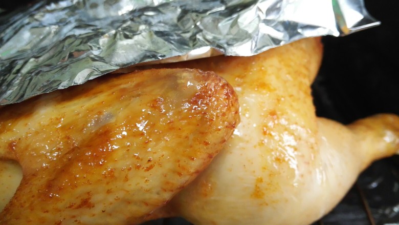 微辣版烤鸡,为了鸡肉能更好的受热，已经金黄的部位用锡纸盖上，这样其他地方还能继续受热