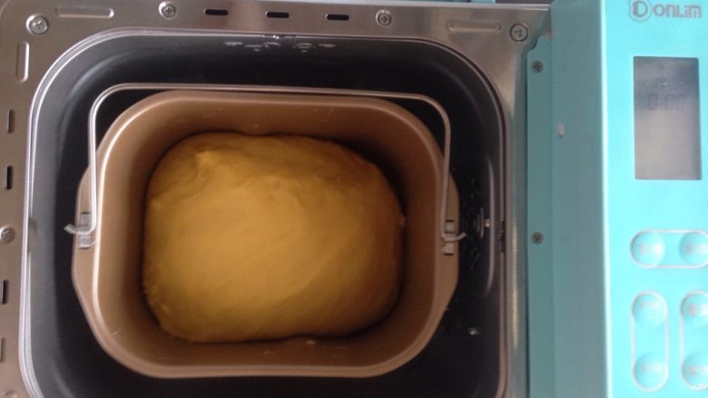 面包机版胡萝卜吐司,面团发酵时，可以在面包桶上盖一块湿布，再盖上面包机盖。这是发酵好的面团