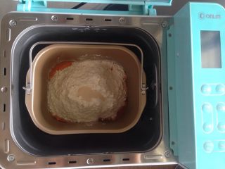 面包机版胡萝卜吐司,在面粉顶端加入酵母，将面包桶放入到面包机内