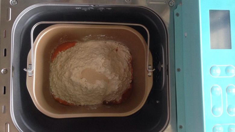 面包机版胡萝卜吐司,在面粉顶端加入酵母，将面包桶放入到面包机内