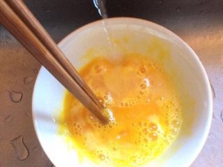 洋葱粉丝炒鸡蛋,加入一勺左右清水搅拌均匀